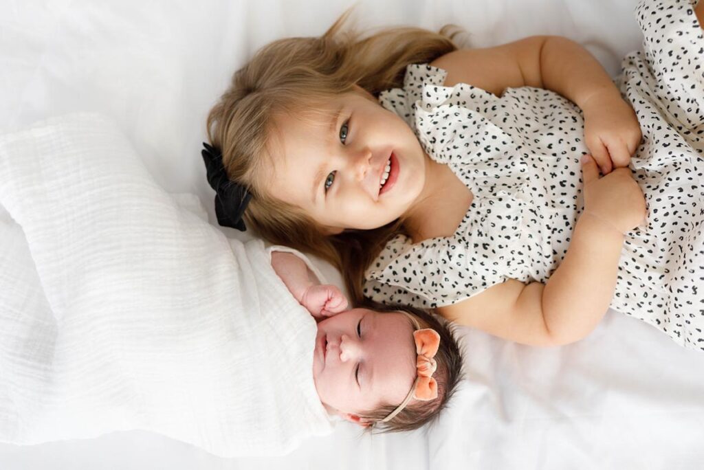 newborn-photography-ideas-sisters laying down togeter