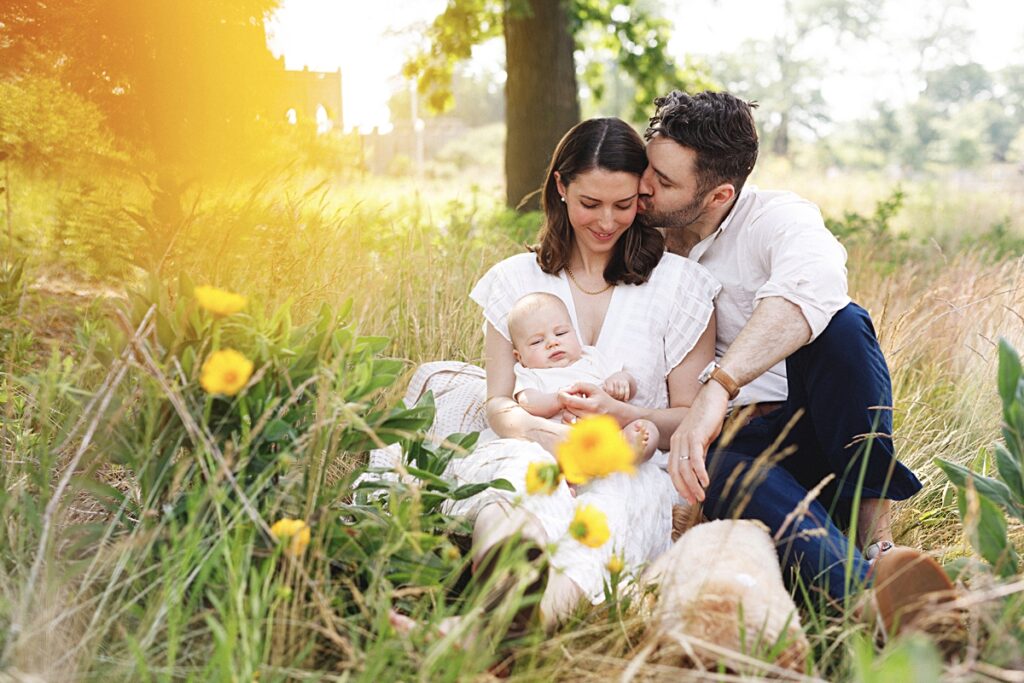 a family cuddles in the field at south pond in chicago, IL