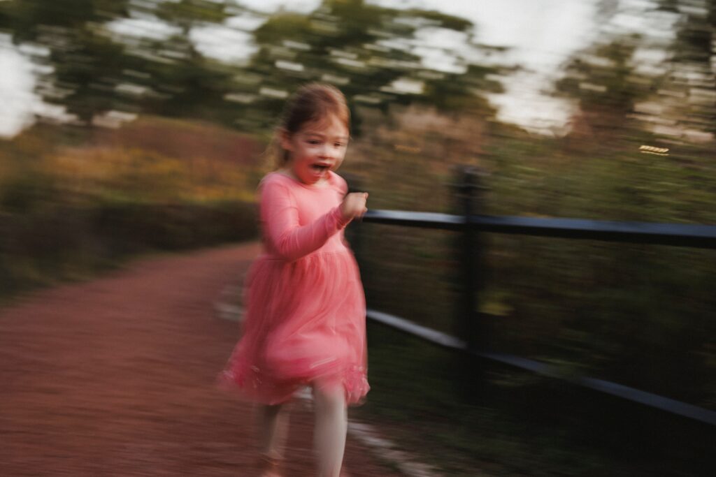 Candid family photography in Humboldt Park with little girl running