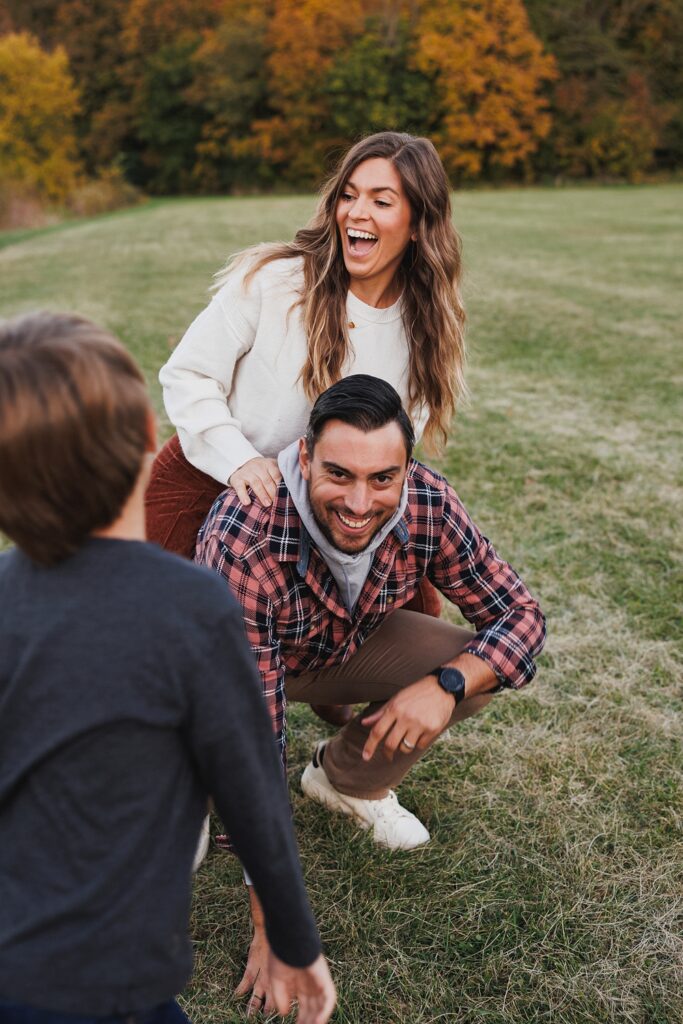 mom and dad play together in fall family photos
