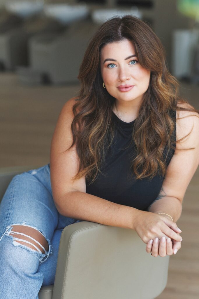 woman posing in natural light at her hair salon