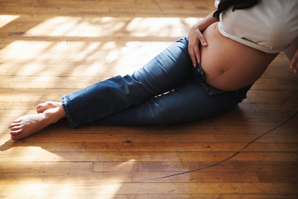 a detail photo of a woman holding her belly during a maternity photoshoot