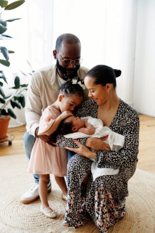 group photo of mom holding a newborn with her daughter snuggling and her husband also hugging them at Rife Ponce Photography a chicago photo studio