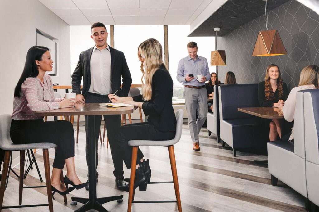 a group of corporate coworkers chat together in the break room