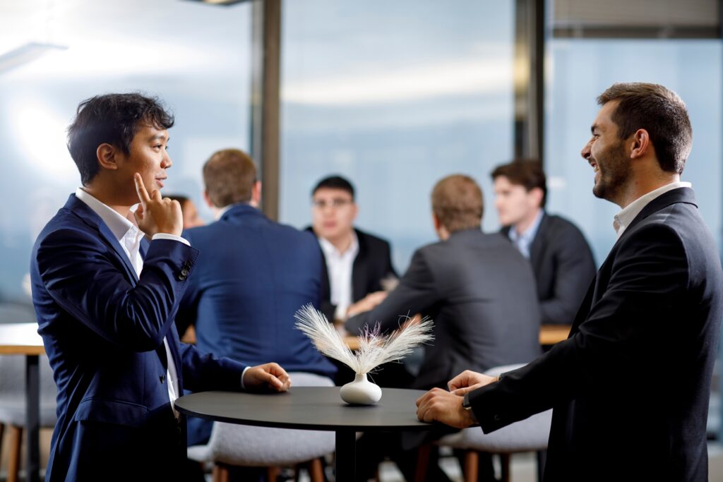 a group of co workers talk around a table at Magnetar financial firm